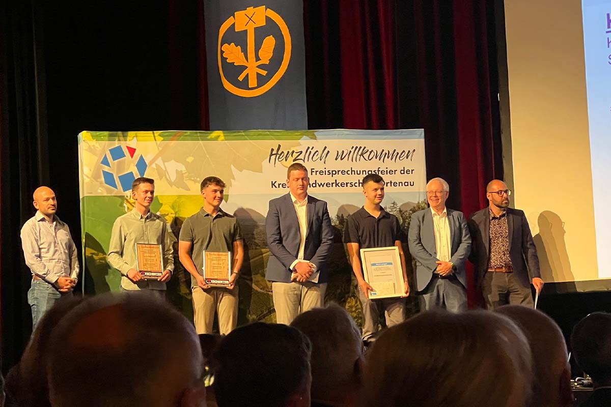 Die Azubis stehen mit Ihrer Auszeichnung auf der Bühne.